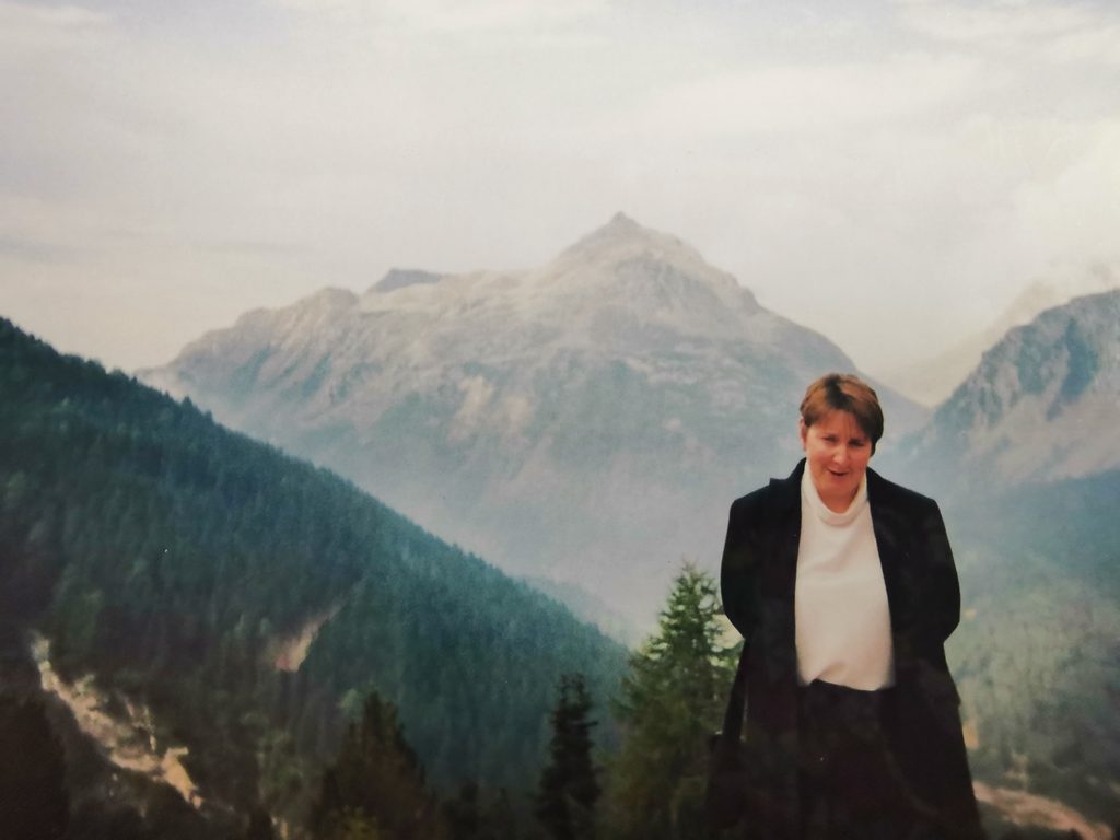 photo of melanie standing on top of hill with mountains in the back